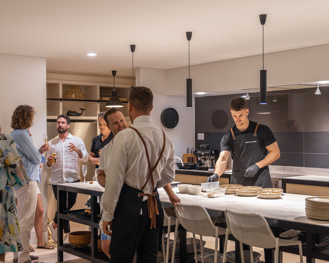 Chef Matt preparing food while guests mingle at a Sydney catering event