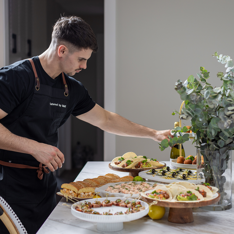 Chef Matt arranging food on table for 80-guest catering event