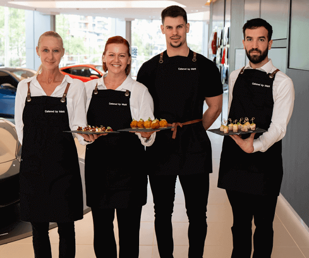 Smiling staff serving canapés at Sydney business lunch catering