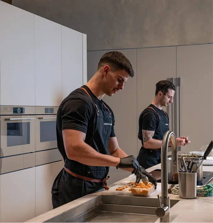 Chefs preparing canapé trays in a home kitchen for a party of 80 guests