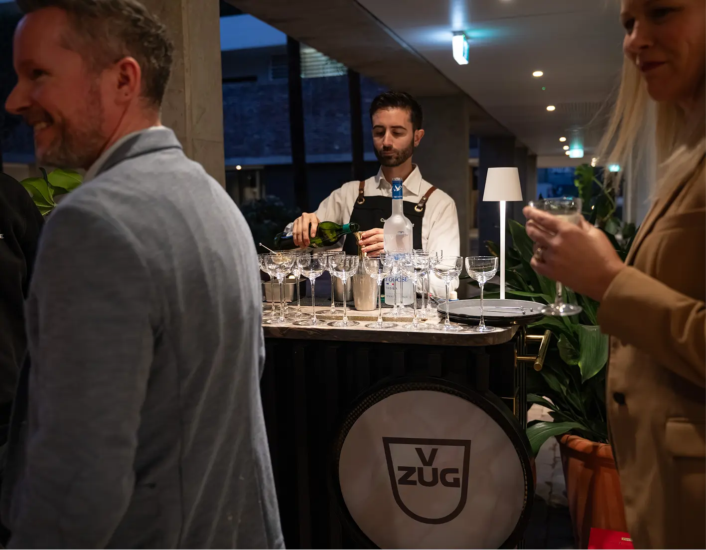 Bartender pouring champagne at a bar set up for a corporate launch event