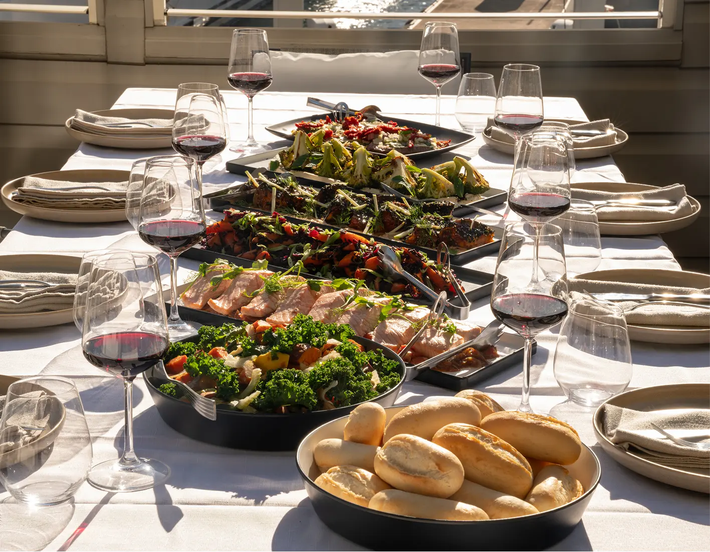 Shared platters of meats, salads and bread set along a long table for a team lunch