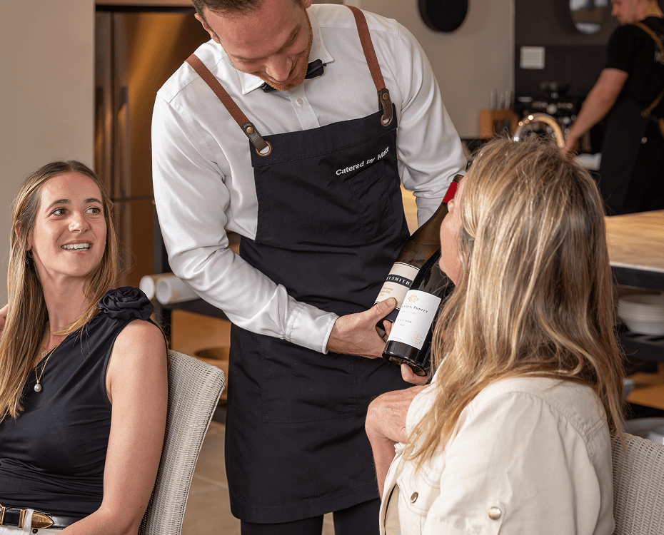Waiter presenting wine bottle to guests at Sydney catering event