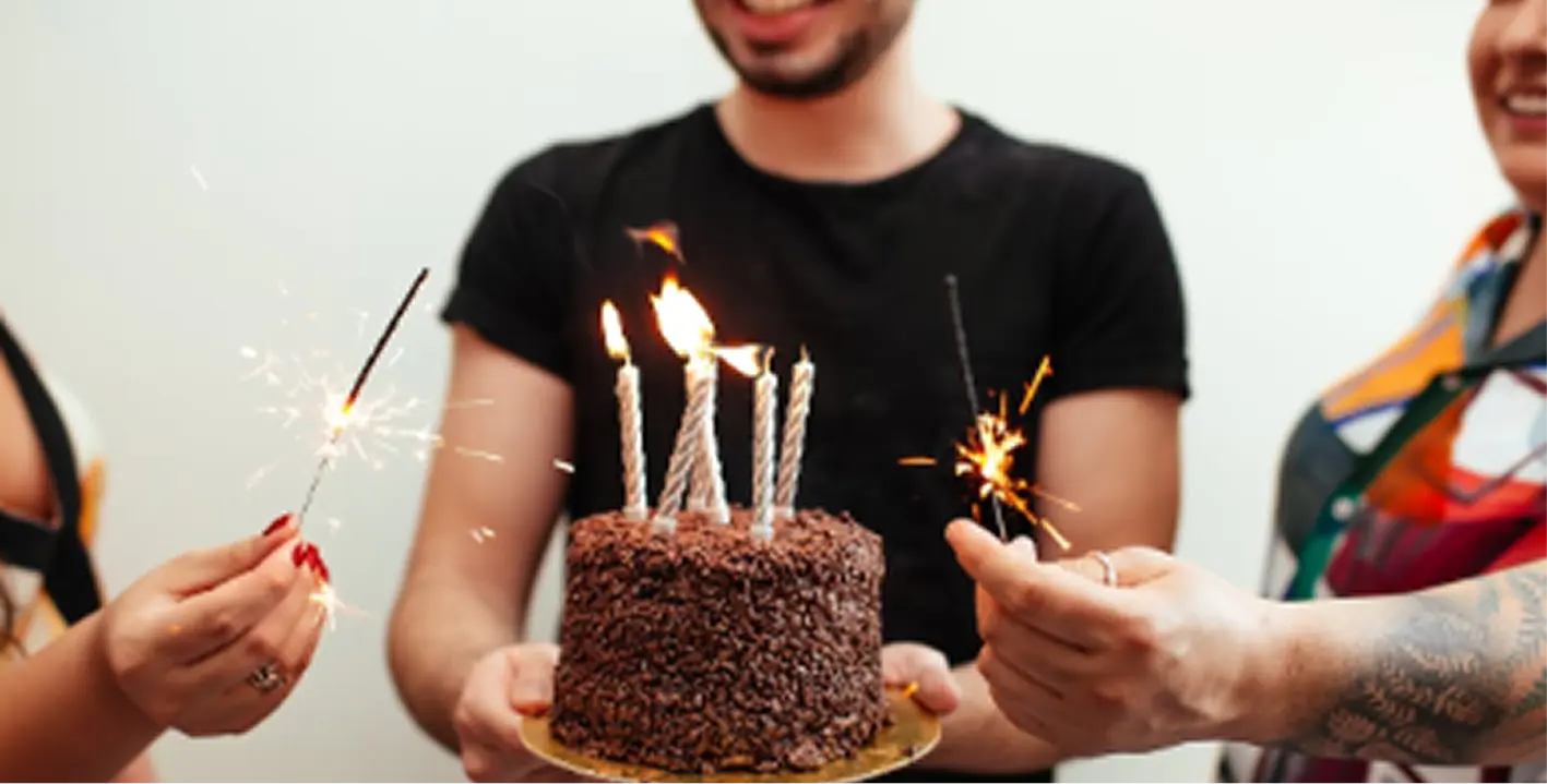 Group celebrating a 40th birthday with cake and sparklers