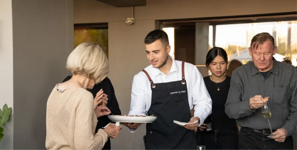 Waiter offering canapés to guests at a birthday party in a Sydney home