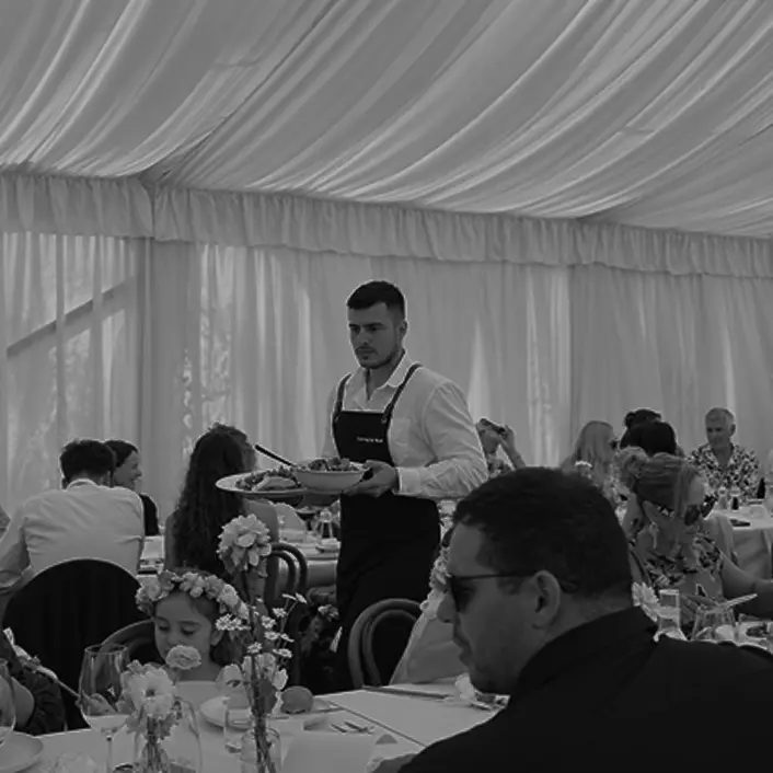 Waiter serving a shared dish to seated guests at a Mona Vale engagement party