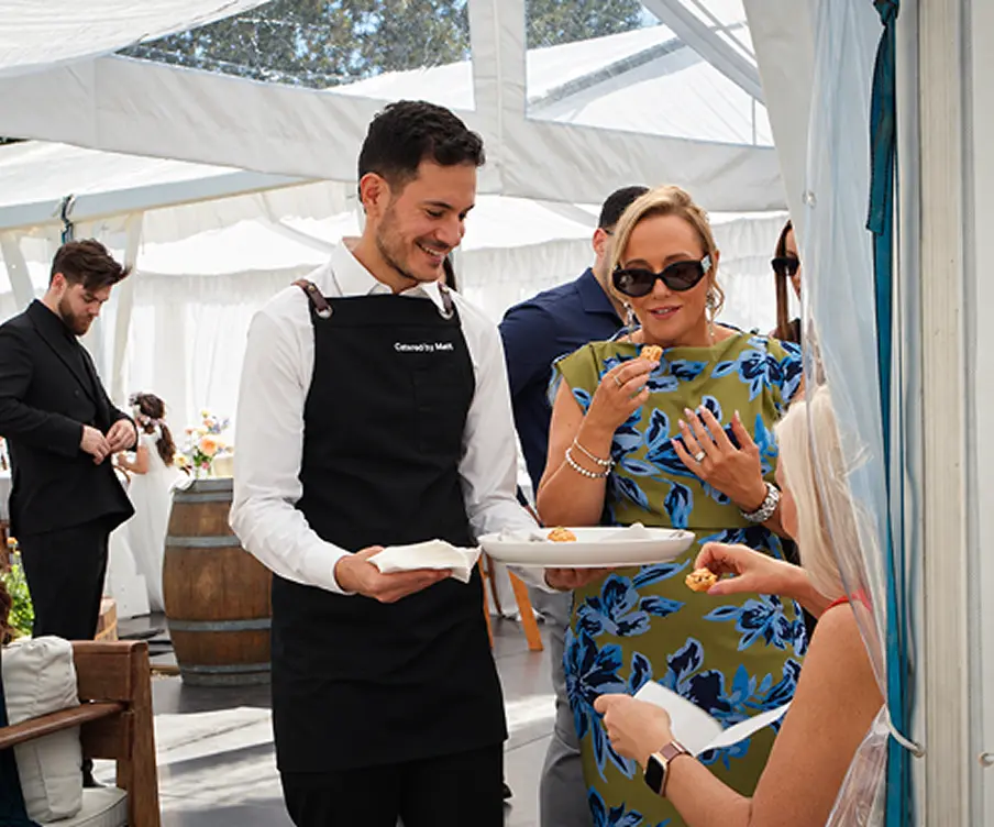 Waiter offering canapés to guests at a marquee celebration in Sydney's Inner West