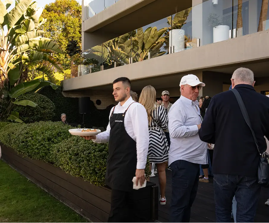 Waiter serving canapés to guests at an outdoor North Shore event