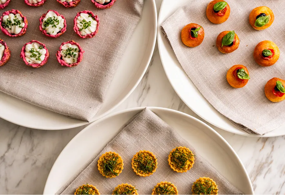 Trays of beetroot cups, tomato and basil bites and tartlets for a Mosman event