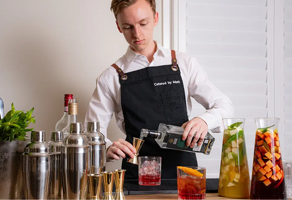 Bar staff mixing cocktails at a bar setup for a North Sydney event
