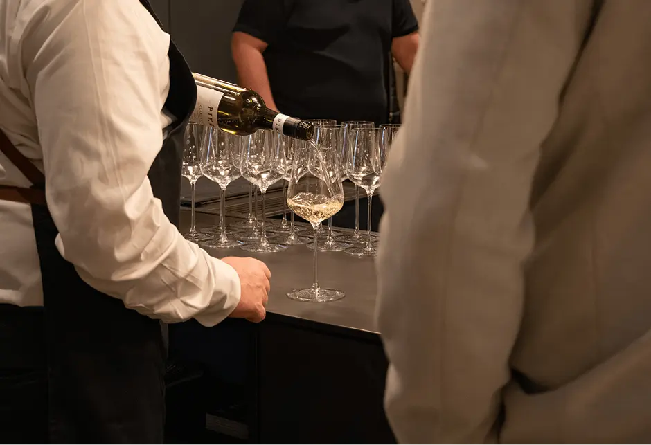 Waiter pouring rows of wine glasses at a North Shore event