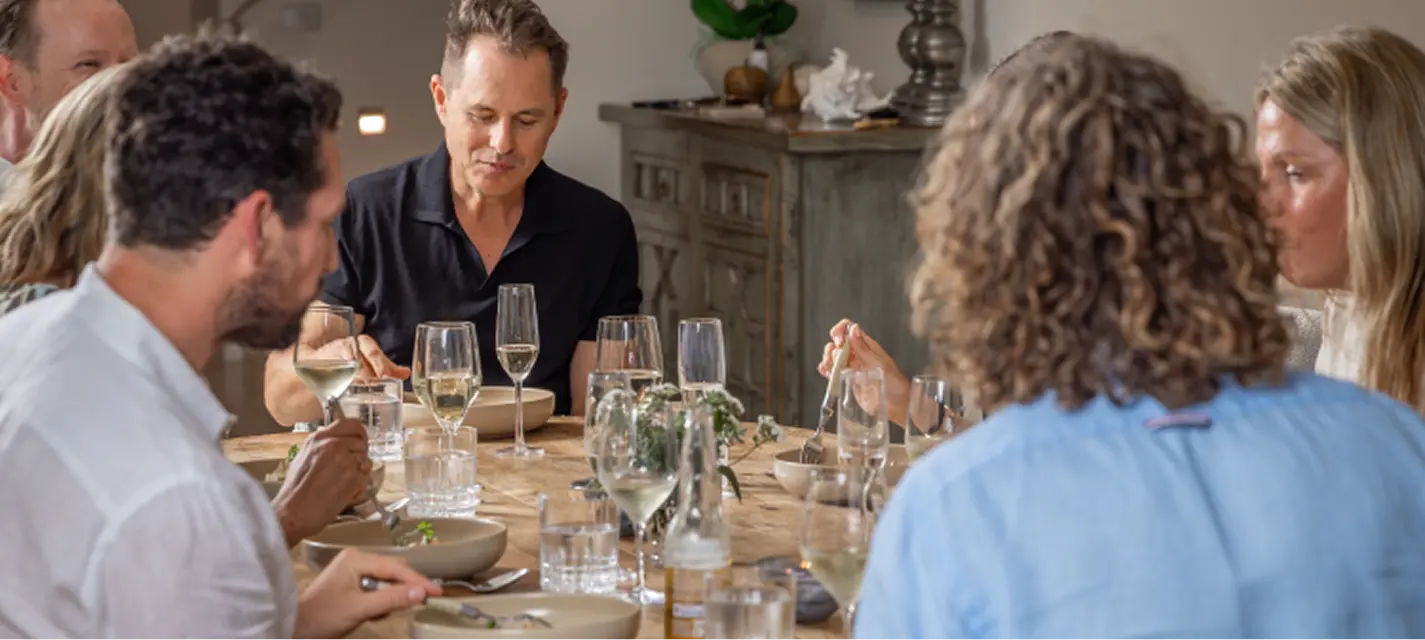Guests seated over white wine as courses are served at a Shire dinner party