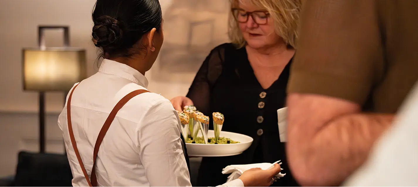 Waitstaff offering a bowl of cone canapés to a guest at a Mosman event