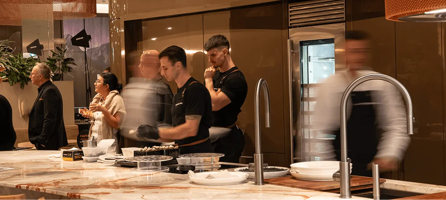 Catering team working a kitchen bench as guests arrive at a North Sydney function