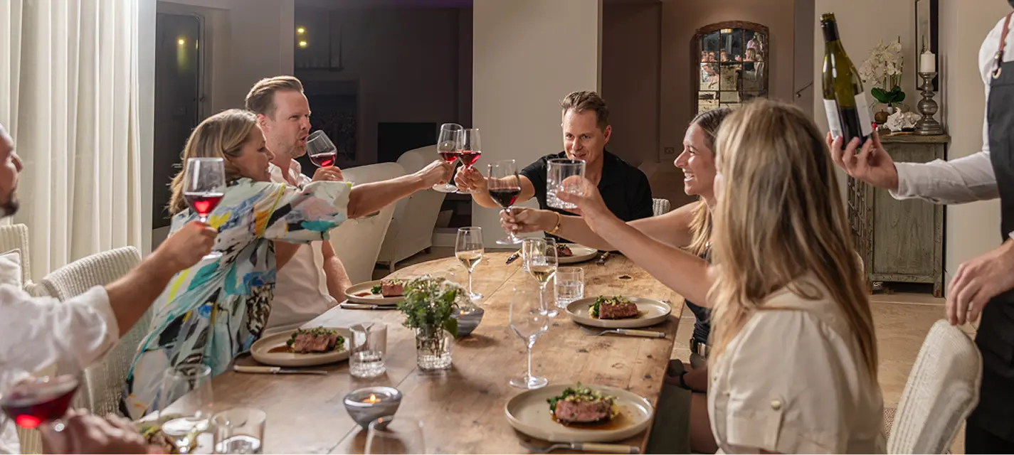 Guests raising a toast over red wine at a Parramatta dinner party