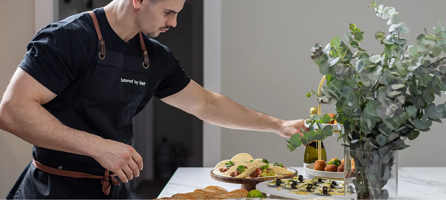Chef Matt arranging canapé stands on a bench at a Penrith celebration
