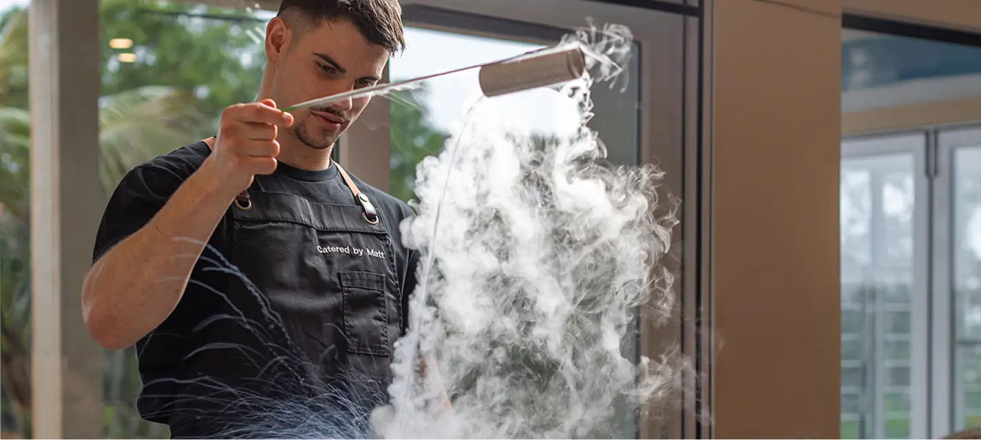 Chef using liquid nitrogen to finish a dish at a Castle Hill event