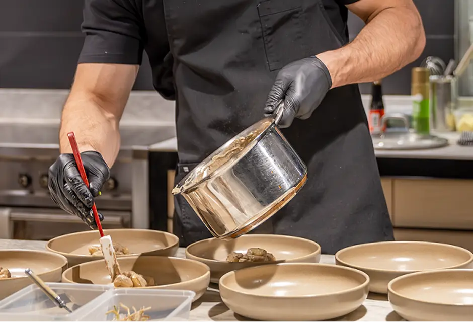 Chef finishing bowls of food during service at a Penrith event