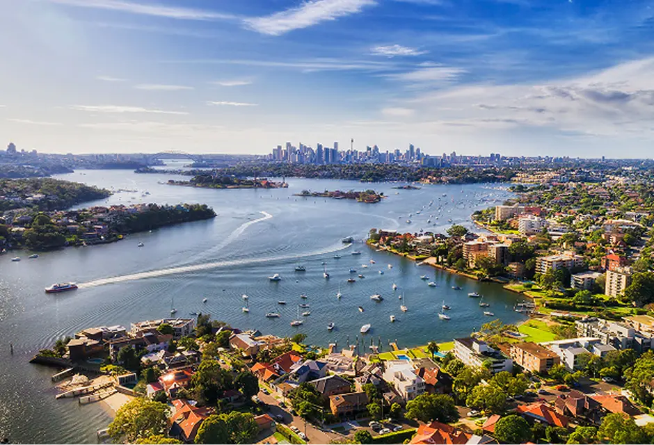 Harbour, moored boats and the city skyline beyond the Inner West waterfront