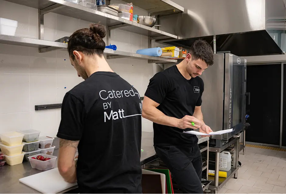 Catered by Matt chefs prepping and checking the run sheet in the kitchen before a North Shore event