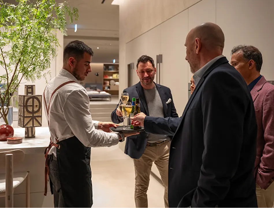 Guests taking drinks from a waiter while hosting their own Mosman event