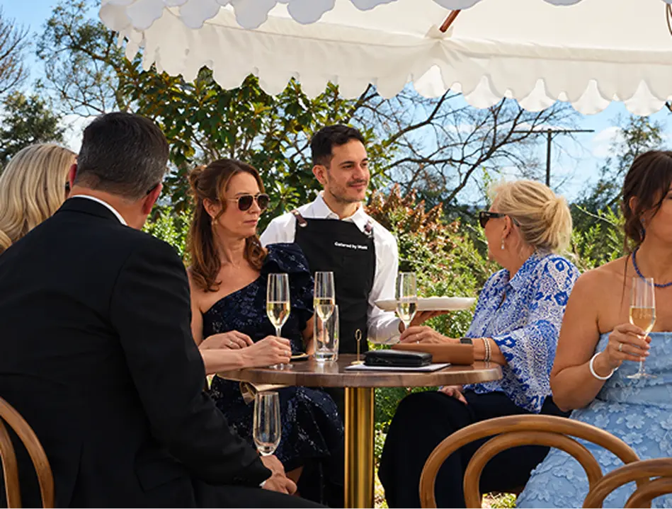 Waiter attending a table of guests at an outdoor Inner West event