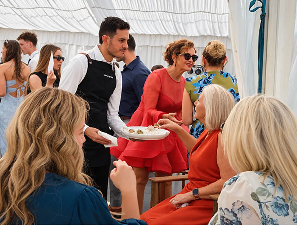Waiter serving a course to seated guests at a North Shore celebration