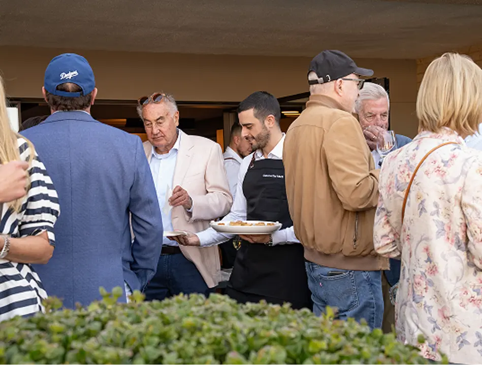 aiter serving canapés among guests at a Northern Beaches event
