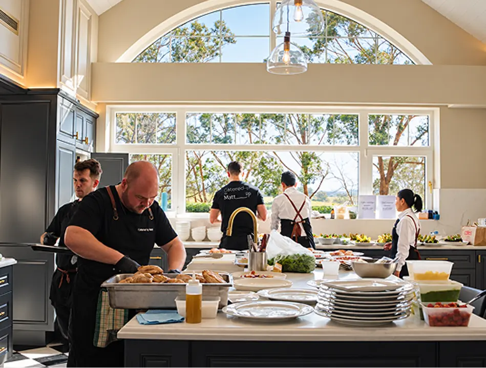 Catering team plating courses in the kitchen at a Penrith event