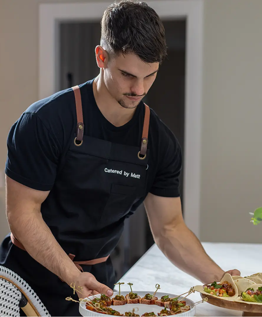 Chef Matt setting out canapés on a stand at a Castle Hill event