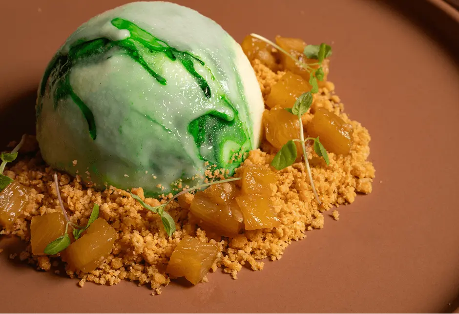 Plated dessert with pineapple, crumb and a green glazed sphere for a Campbelltown dinner