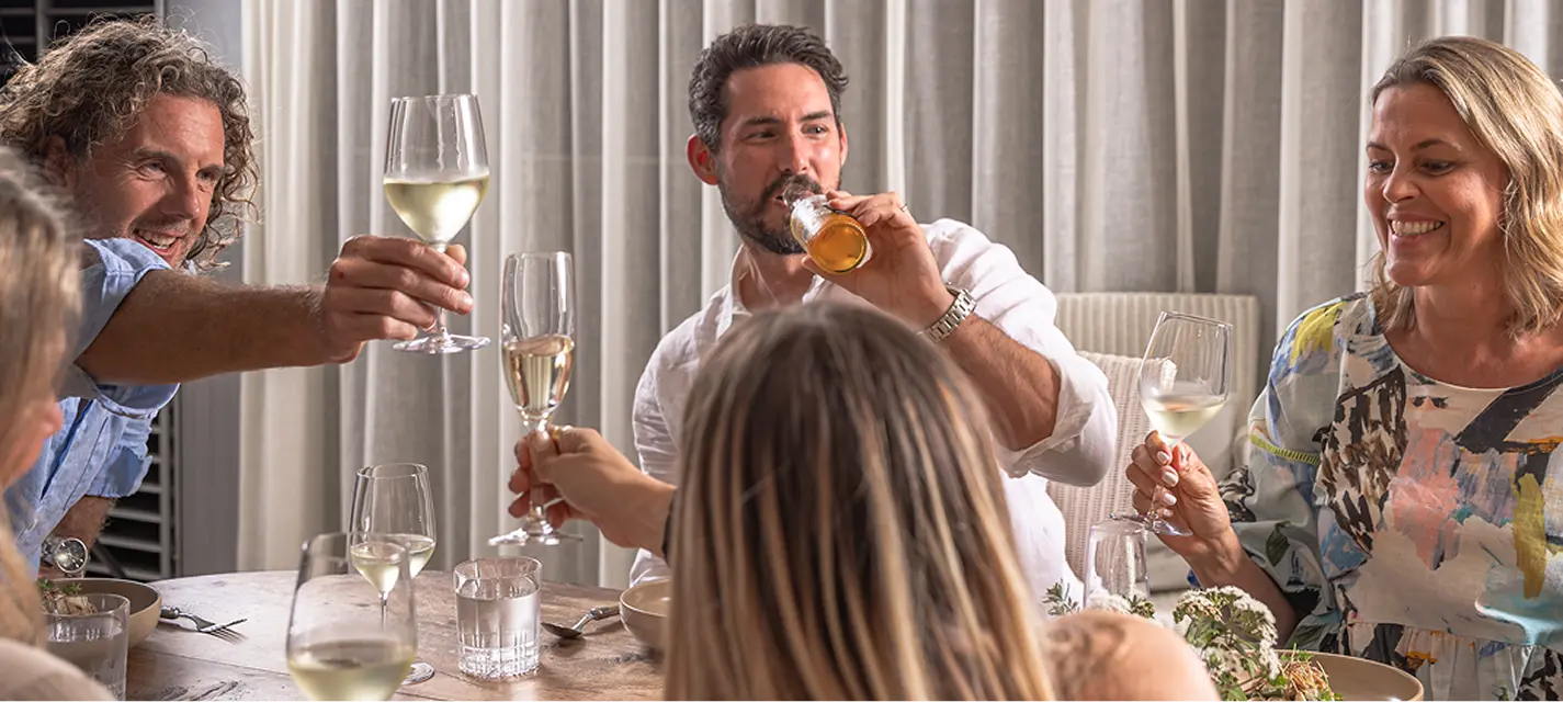 Guests raising a toast over white wine at a Campbelltown dinner party