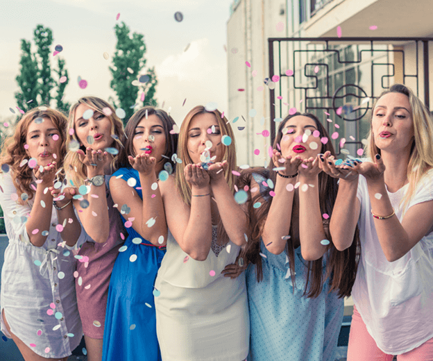 ​​Sydney bridal shower catering guests blowing confetti and celebrating together