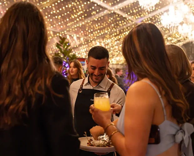 Waiter serving drinks to guests at a Sydney home party