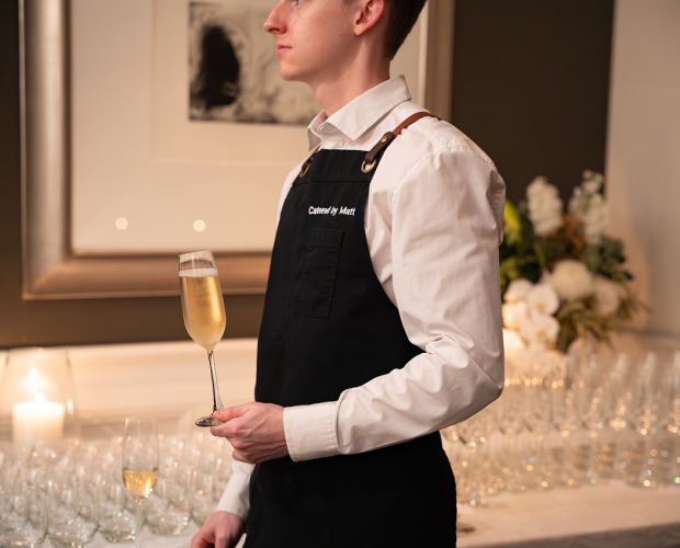 Well-dressed waiter carrying champagne at Sydney city corporate dinner